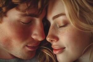 A tender moment shared between a young Caucasian couple, their foreheads gently touching with eyes closed, radiating warmth and intimacy. photo