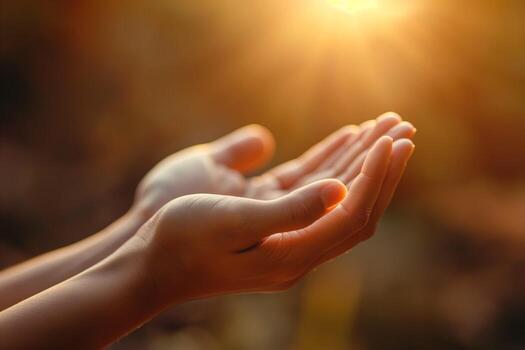 A pair of gentle hands, illuminated by warm sunlight, symbolizing hope and openness. photo