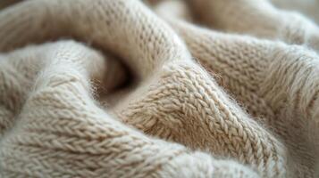 Close-up of a soft beige knitted fabric, showcasing intricate textures and cozy appearance. photo