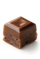 A close-up of a rich, glossy chocolate caramel cube on a white background. photo
