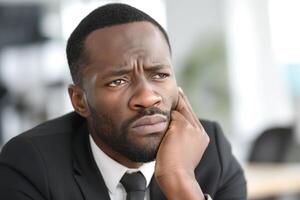 Thoughtful African American man in a suit, contemplating a decision in a modern office setting. photo