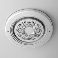A modern white ceiling speaker that blends seamlessly into a minimalistic interior design. photo
