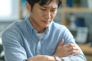 Concerned Asian man checking his watch, reflecting on time management at work. photo