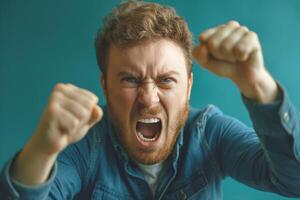 Angry Caucasian man with curly hair expressing frustration against a teal background. photo