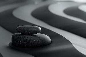 Two smooth black stones sit atop a rippled gray surface, creating a serene and minimalist composition. photo