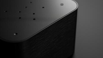 Close-up of a sleek black device with textured surface and small perforations, evoking a modern, high-tech aesthetic. photo