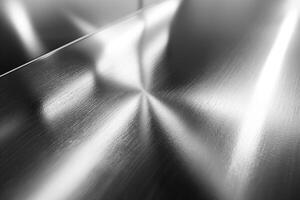 Close-up view of a brushed metallic surface, showcasing intricate patterns and reflections. photo
