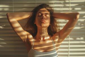 A young woman with long hair poses in soft sunlight, creating a striking interplay of shadows and light across her face. photo