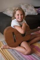 Girl with guitar smiling and looking at camera photo