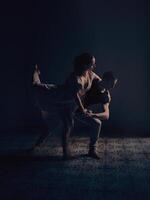 Ballet dancers performing dance in dark studio photo