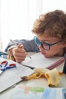 Focused boy reading notes in notebook at home photo