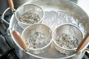Process of cooking noodles in saucepan with boiling water photo
