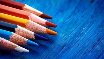 Colorful Pencils Arranged on a Blue Wooden Surface Create an Artistic Display in a Creative Workspace photo