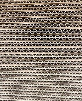 Close-up of stacked cardboard sheets, repeating pattern and texture of material. High quality photo