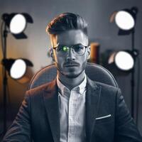 A man in glasses sitting in front of a camera photo