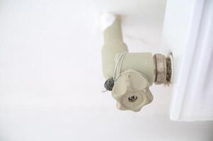 close-up of a plastic valve that fits into the heating system. pipe and radiator with the heating system. there is a seal on the valve. the tap is sealed photo