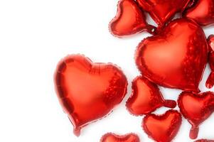 White background for text and foil balloons in the shape of hearts. Balloons of various sizes from large to small hearts. Balloon hearts are located on the right side of the background. photo