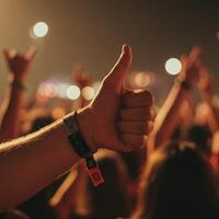 A person giving the thumbs up at a concert photo