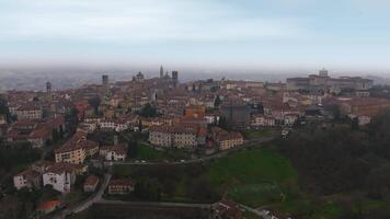 Panoramic aerial view of Bergamo's old town in Italy, showcasing medieval architecture, ancient walls, and towers with smooth motion over the hilltop area. video