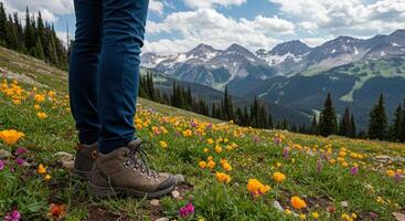 A person wearing hiking boots standing in a field of wildflowers photo