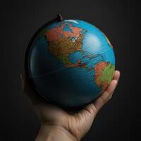 A person holding a globe on a black background photo