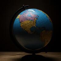 A globe on a wooden table with a dark background photo