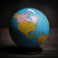 A globe on a wooden table with a dark background photo