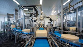 Dairy factory with robotic arms and conveyor belts, automation of cheese production for enhanced efficiency and increased output. Food production concept photo