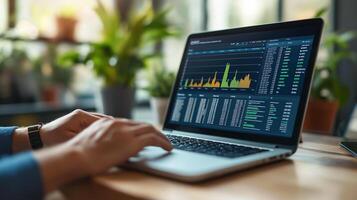 A person analyzes stock market data on a laptop, reviewing financial charts and trends in a modern, plant-filled workspace. photo