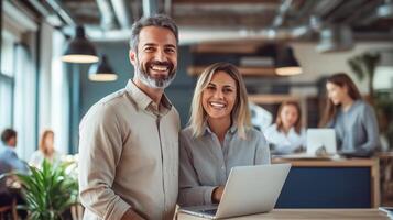 Smiling business professionals working together on a laptop in a modern office, fostering teamwork and productivity. photo