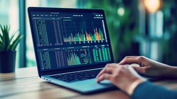 A person analyzes stock market data on a laptop, reviewing financial charts and trends in a modern workspace with plants. photo