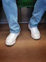 A person sitting on a subway train with their feet on the floor photo