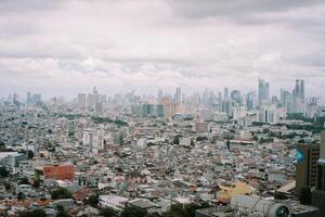 Jakarta cityscape view with densely packed houses under overcast sky photo