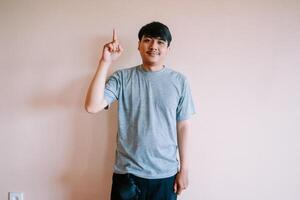 Enthusiastic asian man pointing upwards towards an idea concept photo