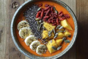 Enjoying a Fresh Fruit Smoothie Bowl with Banana Mango and Goji photo