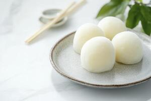 Serving of Delicious Mochi on Plate with Chopsticks and Leaf photo