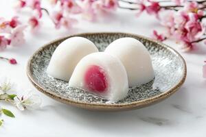 Three Mochi Desserts on Plate with Cherry Blossom Background photo