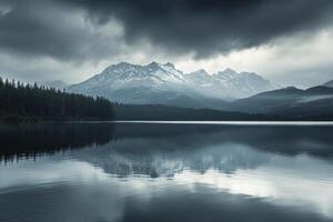 Reflecting Lake Waters Under Overcast Sky with Mountains and Pine Trees photo