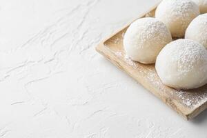 Mochi Rice Cake on Wood Tray with Powdered Sugar Dessert photo