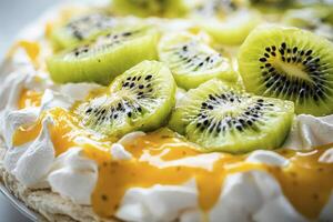 Close-up of Pavlova Cake Topped with Kiwi Slices and Mango Sauce photo