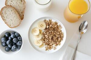 Enjoying Nutritious Breakfast Bowl with Yogurt Banana Granola Berries and Toast photo