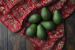 Fresh Avocado Grouping on Red Patterned Cloth Over Rustic Wooden Table photo