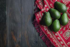 Avocado Still Life on Rustic Wooden Table with Red Patterned Cloth photo