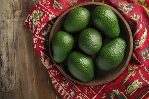 Fresh Avocados in Wooden Bowl on Rustic Table with Textile Background photo