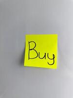 The word Buy is written with marker on sticky note photo