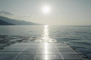 Solar Panel Array Above Water Reflecting Sunlight with Mountain Backdrop photo