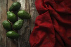 Fresh Avocados on Rustic Wooden Table with Red Fabric Drape photo