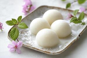 Delicious Mochi Arrangement with Spring Blossoms on Plate for Asian Dessert photo