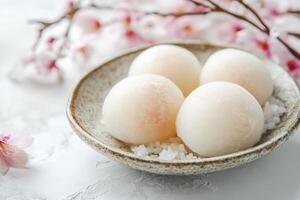 Japanese Mochi Dessert on Plate with Cherry Blossoms Decoration Close-up photo