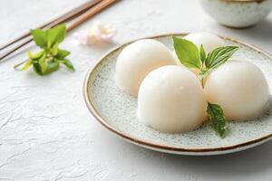 Delicious Mochi Ice Cream on Plate with Mint and Chopsticks photo